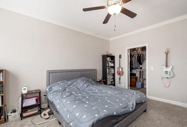 carpeted bedroom featuring a closet, crown molding, baseboards, ceiling fan, and a spacious closet