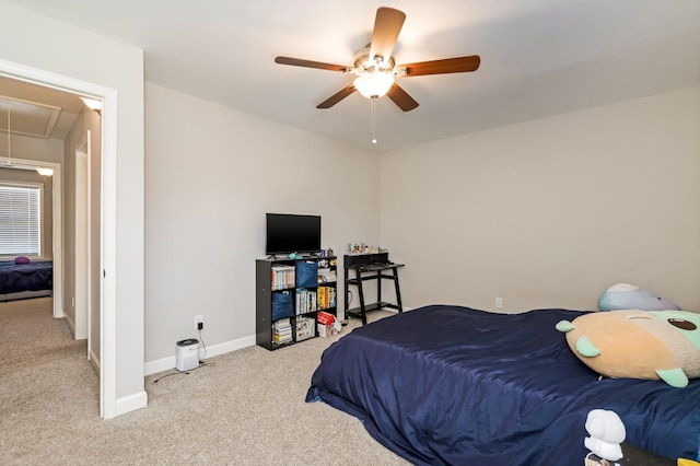 carpeted bedroom featuring ceiling fan, attic access, and baseboards