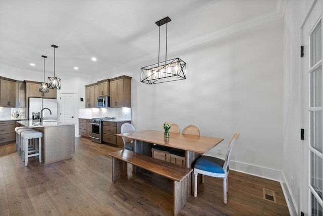 dining area with visible vents, ornamental molding, and dark wood-style flooring