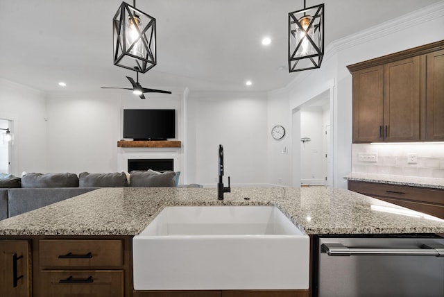 kitchen featuring a sink, open floor plan, a fireplace, and ornamental molding