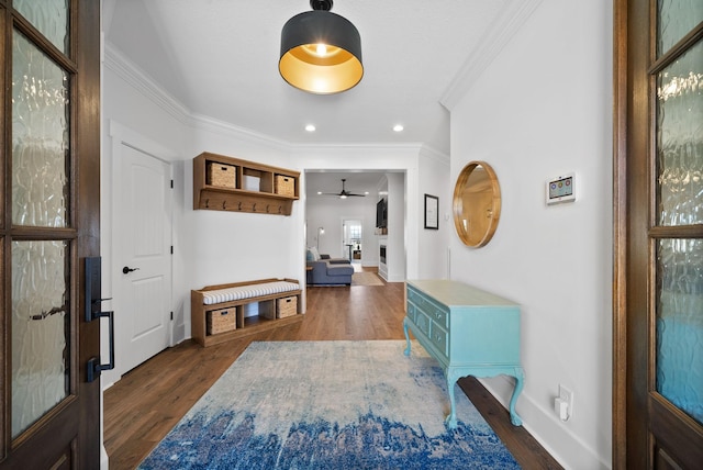 foyer entrance featuring baseboards, wood finished floors, a ceiling fan, and ornamental molding