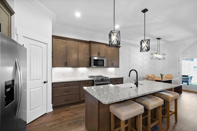 kitchen with decorative backsplash, stainless steel appliances, crown molding, and a sink