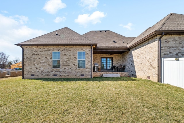 back of house featuring a shingled roof, a lawn, brick siding, and crawl space