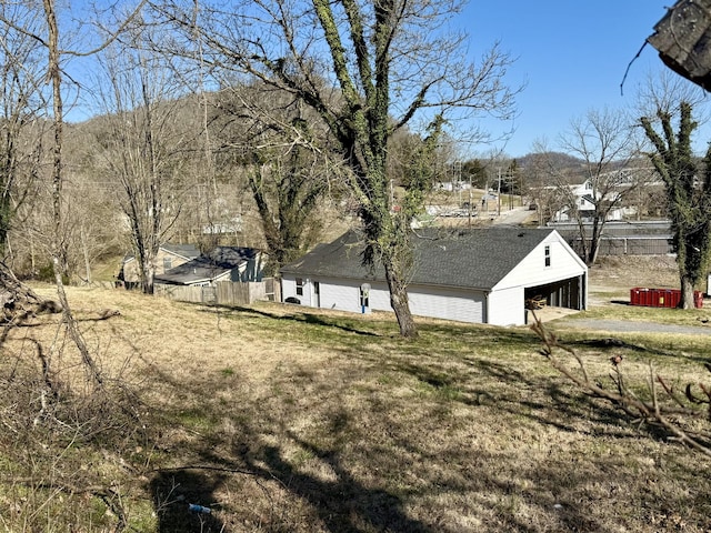 view of yard featuring an outbuilding, a garage, and fence