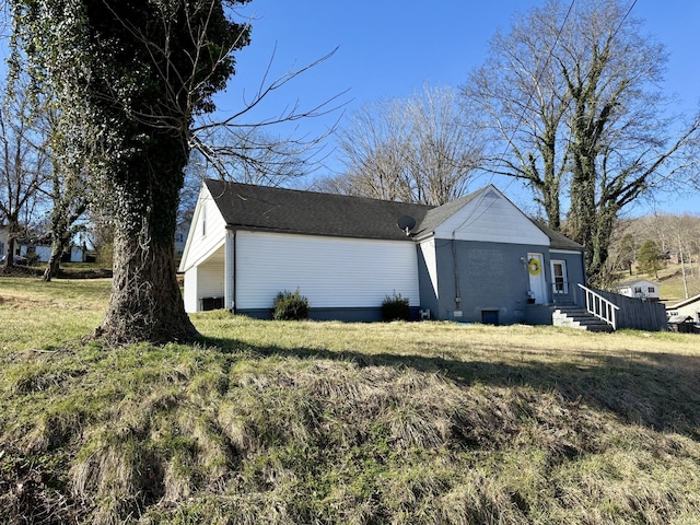 view of home's exterior with entry steps and a yard