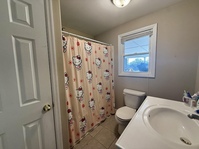 full bathroom with curtained shower, tile patterned floors, toilet, and a sink