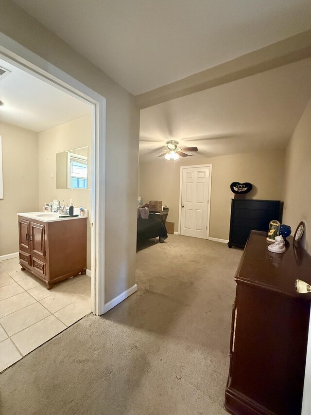 interior space with visible vents, light colored carpet, baseboards, and ceiling fan