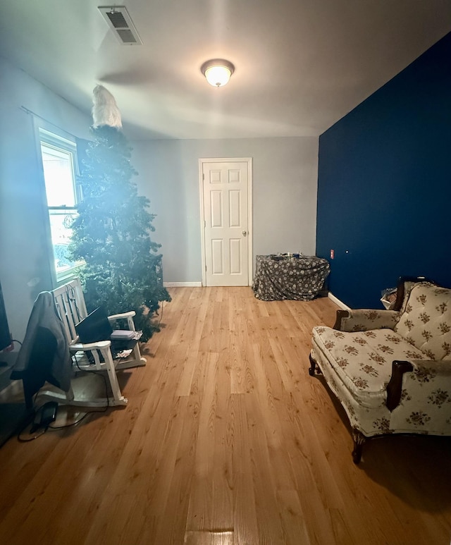 sitting room featuring visible vents, baseboards, and wood finished floors