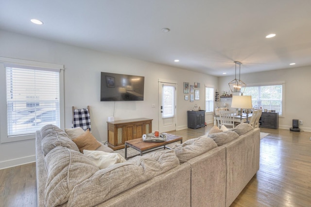 living room featuring light wood finished floors, recessed lighting, and baseboards