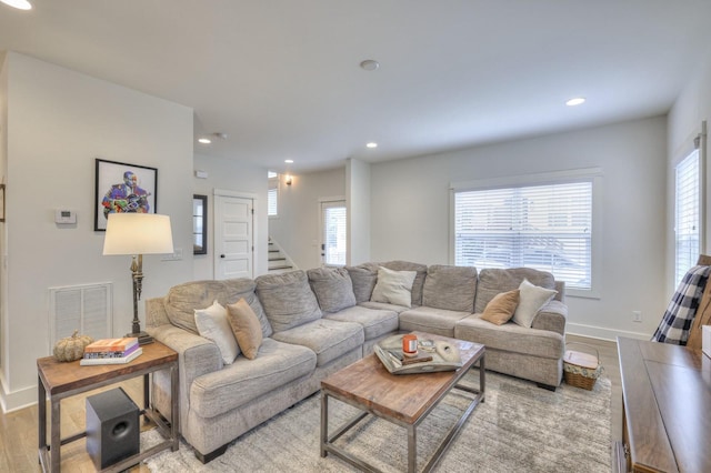 living room with wood finished floors, visible vents, baseboards, recessed lighting, and stairs