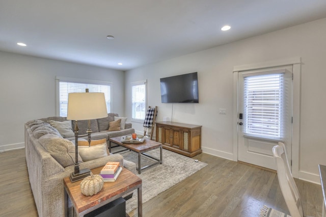 living area with recessed lighting, baseboards, and wood finished floors