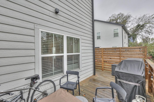 deck featuring grilling area and fence