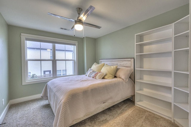 carpeted bedroom featuring a ceiling fan, visible vents, and baseboards