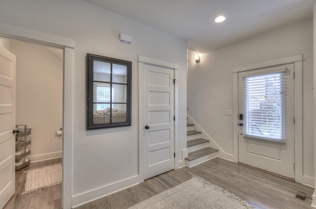 foyer featuring stairs, recessed lighting, wood finished floors, and baseboards