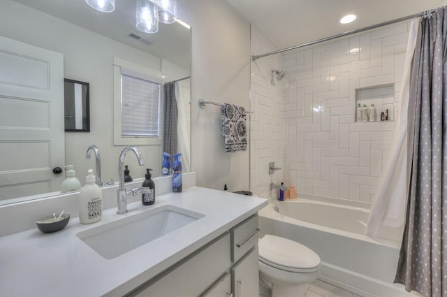 bathroom featuring visible vents, shower / bath combo with shower curtain, toilet, and vanity