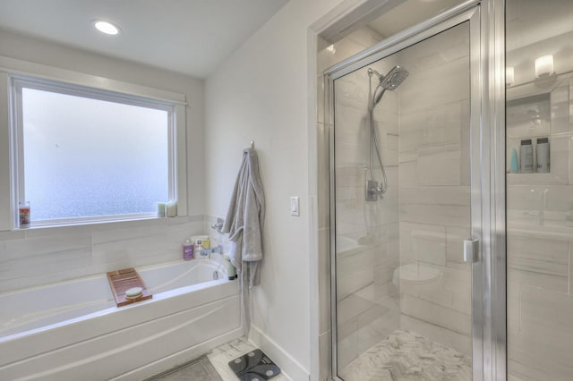 full bathroom featuring a stall shower, baseboards, and a bath