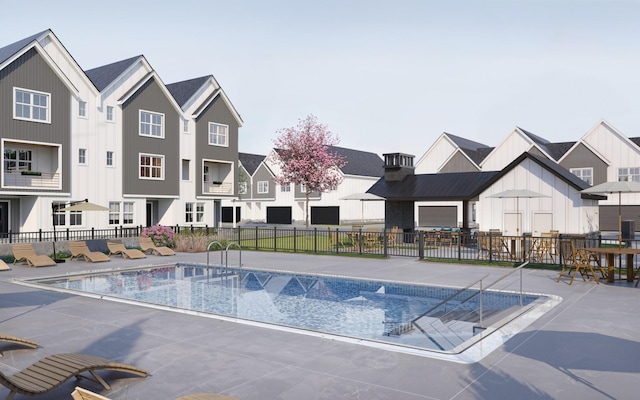 pool with a patio area, a residential view, and fence