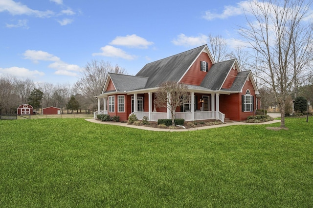 view of side of property with a lawn, covered porch, and a shingled roof