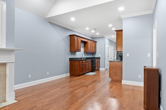 kitchen with baseboards, light wood finished floors, a sink, wine cooler, and crown molding