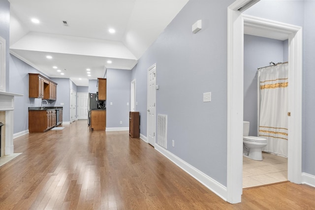 unfurnished living room featuring visible vents, wood finished floors, recessed lighting, baseboards, and lofted ceiling