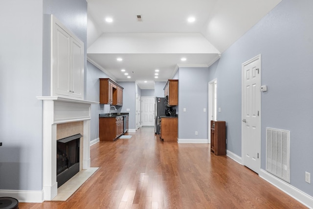 living room with visible vents, light wood-style flooring, a high end fireplace, recessed lighting, and baseboards