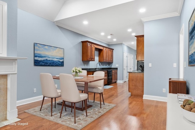 dining space with beverage cooler, light wood-style flooring, ornamental molding, recessed lighting, and baseboards