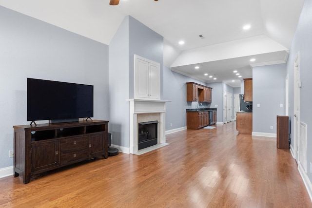 living room with baseboards, light wood-style flooring, and a ceiling fan