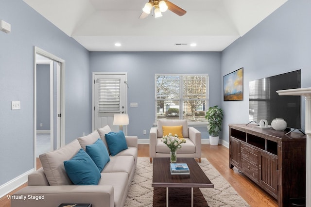 living room featuring recessed lighting, baseboards, and light wood finished floors