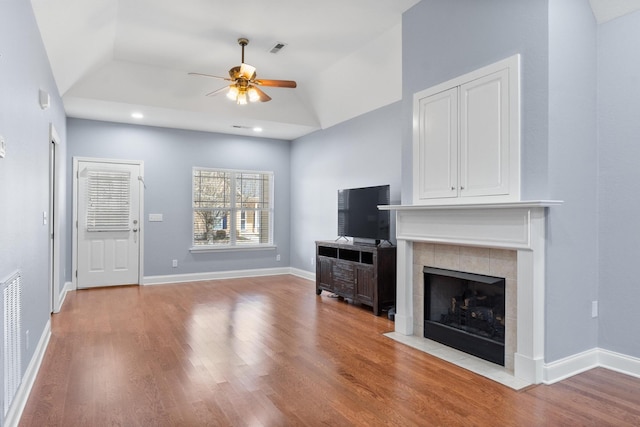 unfurnished living room with visible vents, baseboards, wood finished floors, and a fireplace