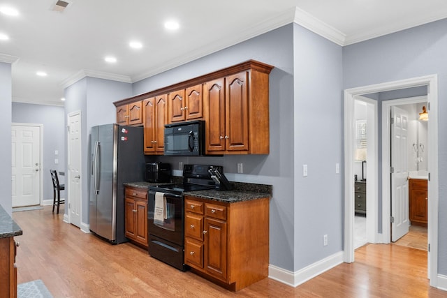 kitchen with light wood-type flooring, visible vents, black appliances, and brown cabinetry