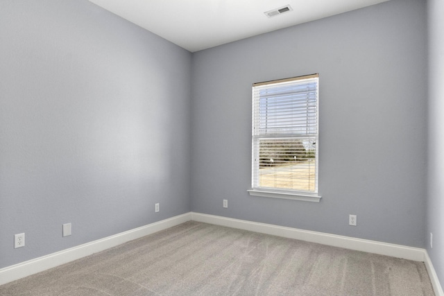 spare room with visible vents, baseboards, and carpet flooring