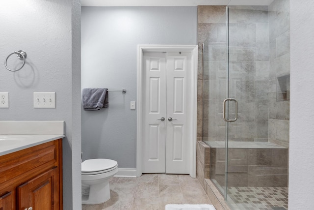 full bath featuring vanity, toilet, baseboards, and a stall shower