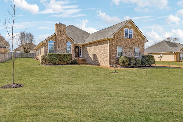 view of front of property featuring a front lawn, fence, a shingled roof, brick siding, and a chimney