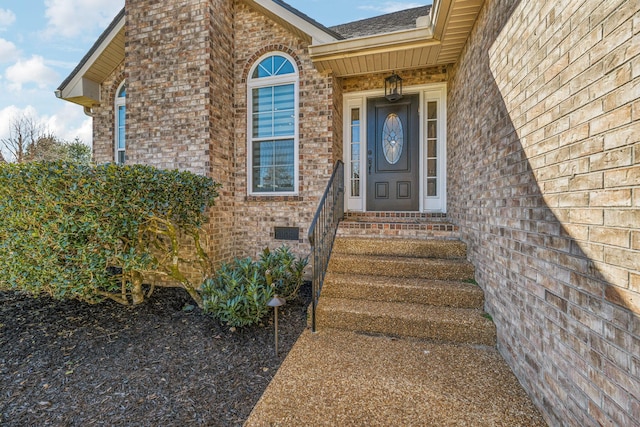 entrance to property featuring brick siding and crawl space