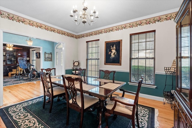 dining space featuring baseboards, an inviting chandelier, crown molding, and light wood finished floors