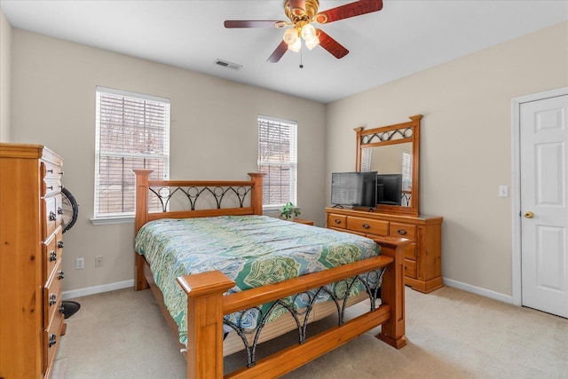 bedroom featuring ceiling fan, light colored carpet, visible vents, and baseboards