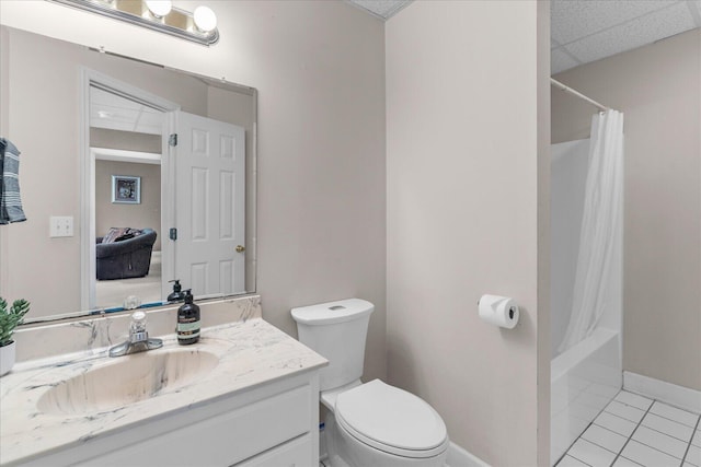 full bath with toilet, tile patterned flooring, a paneled ceiling, baseboards, and vanity