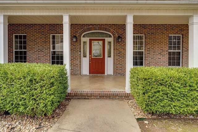 property entrance featuring brick siding and covered porch