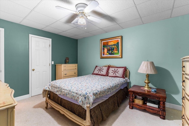 carpeted bedroom featuring a paneled ceiling, baseboards, and ceiling fan