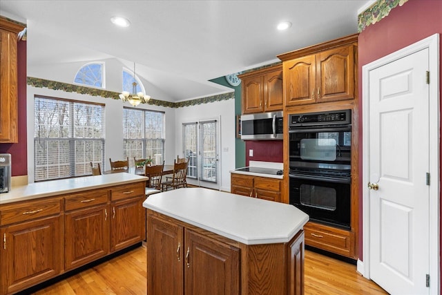 kitchen featuring lofted ceiling, black appliances, light wood-style flooring, and light countertops