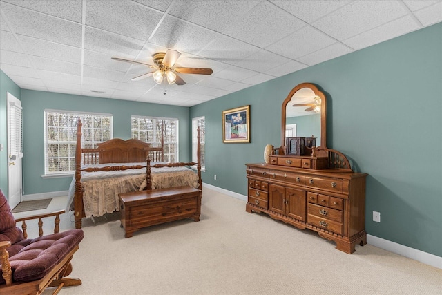 bedroom featuring a paneled ceiling, light carpet, baseboards, and ceiling fan