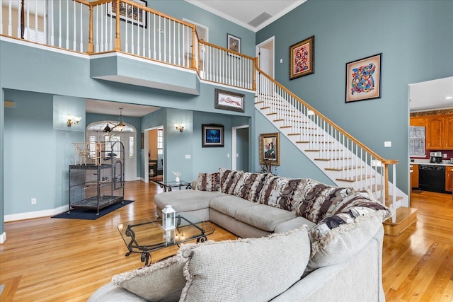 living room featuring crown molding, stairs, baseboards, and wood finished floors