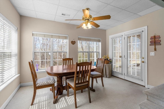 dining space featuring visible vents, baseboards, ceiling fan, light colored carpet, and a paneled ceiling