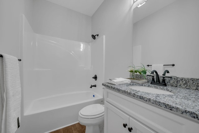 bathroom featuring wood finished floors, toilet, shower / washtub combination, and vanity