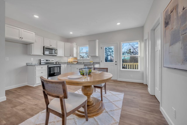 dining area with recessed lighting, light wood-type flooring, and baseboards