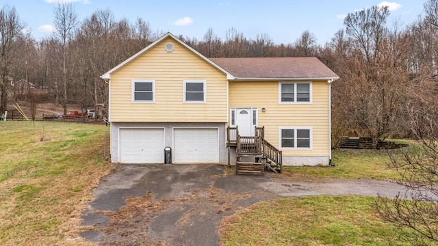 split foyer home featuring aphalt driveway, a garage, and a front yard