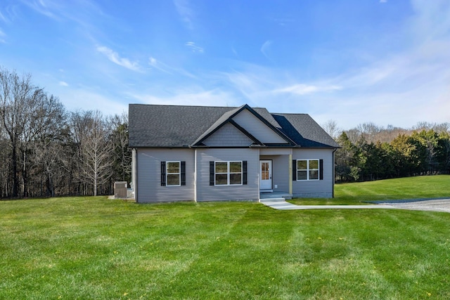 view of front of property featuring a front lawn, central AC, and a shingled roof