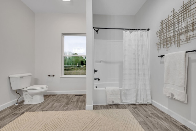 full bathroom featuring shower / bath combination with curtain, toilet, wood finished floors, and baseboards