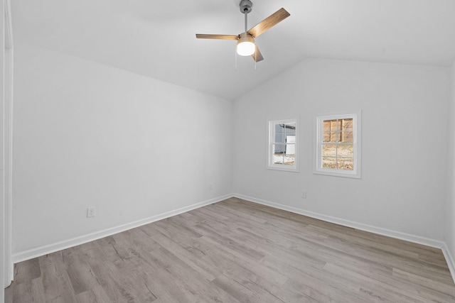 unfurnished room featuring a ceiling fan, vaulted ceiling, wood finished floors, and baseboards