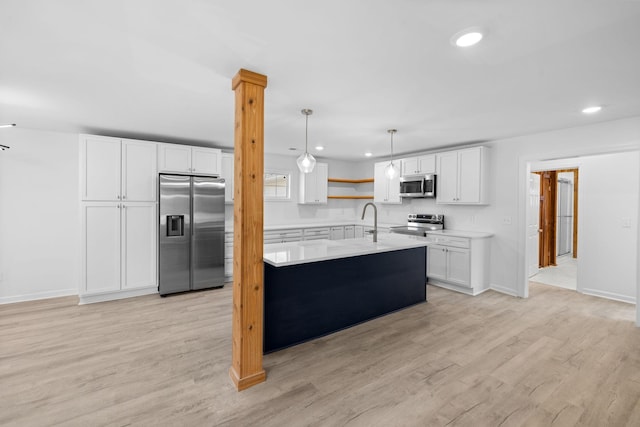 kitchen featuring white cabinetry, light countertops, light wood-type flooring, and appliances with stainless steel finishes